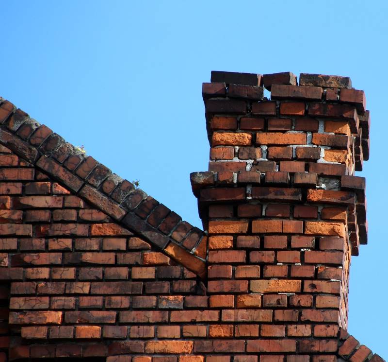 Damaged chimney on an Lincolnwood home showing cracks and missing mortar